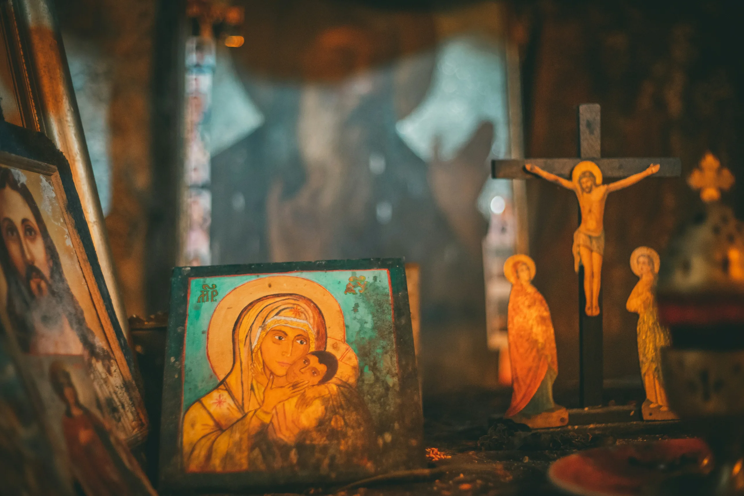 Orthodox icons and a wooden crucifix lit by candlelight
